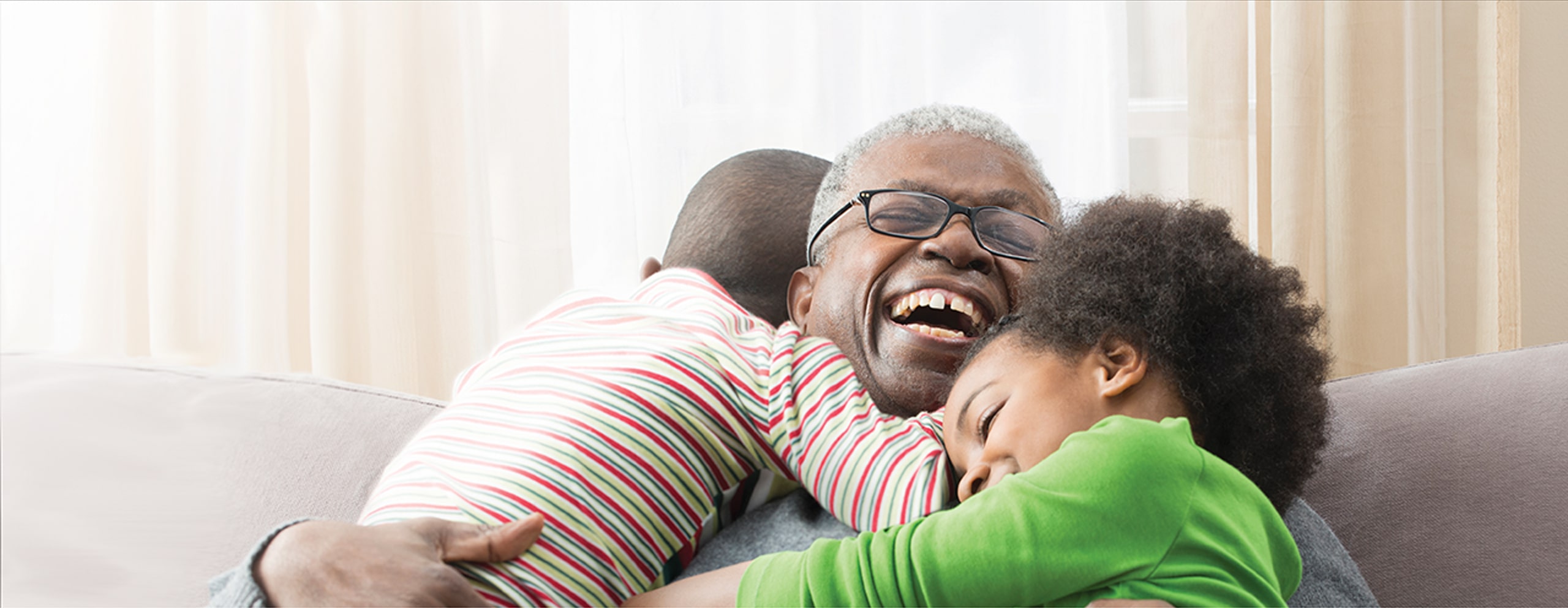 Man with glasses hugging children